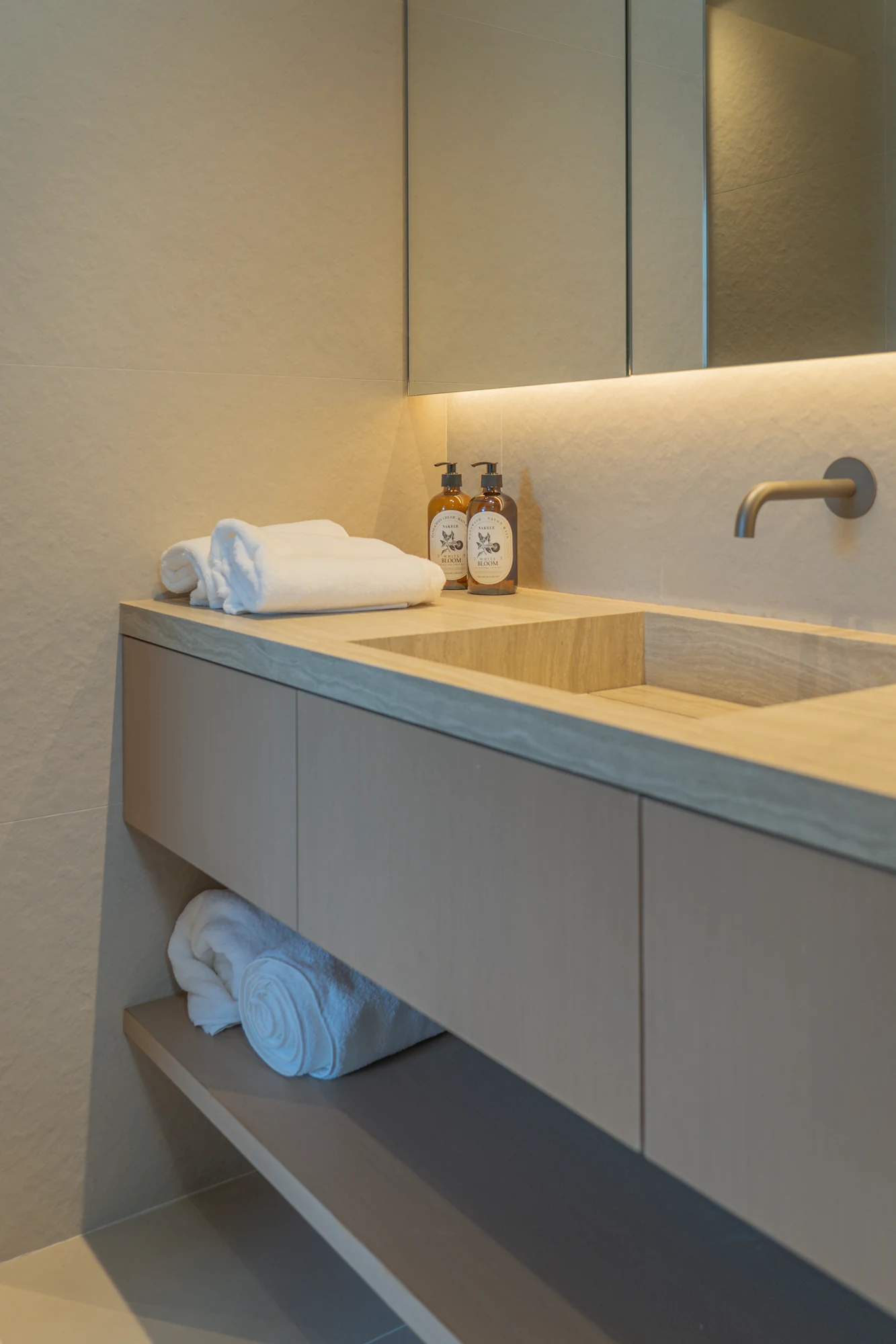 Bathroom vanity with pale cabinet fronts and an open towel shelf