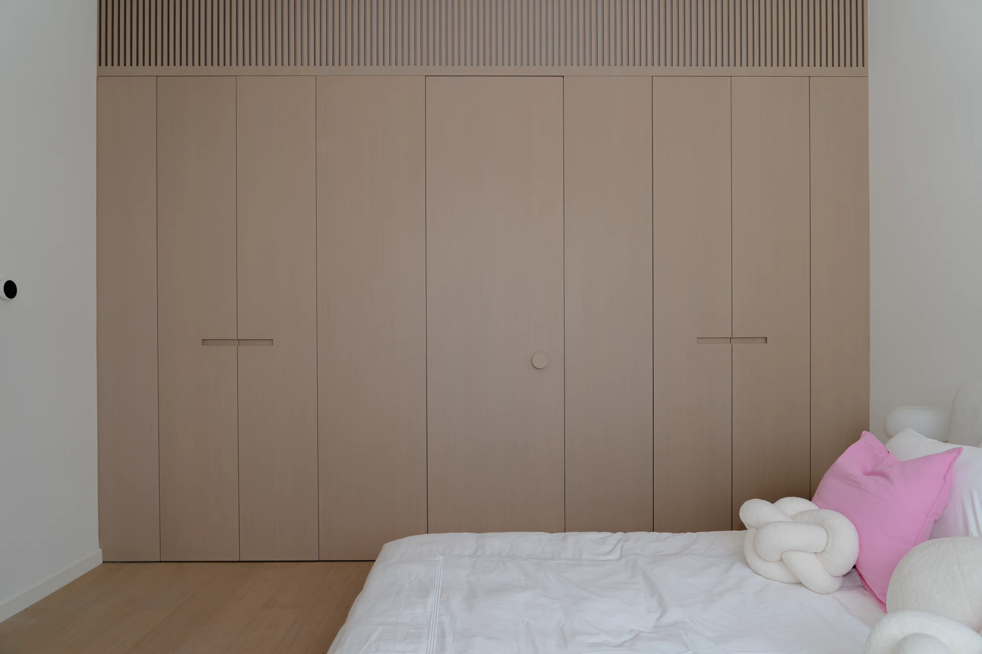 Bedroom joinery with wardrobe doors and an integrated bathroom door closed