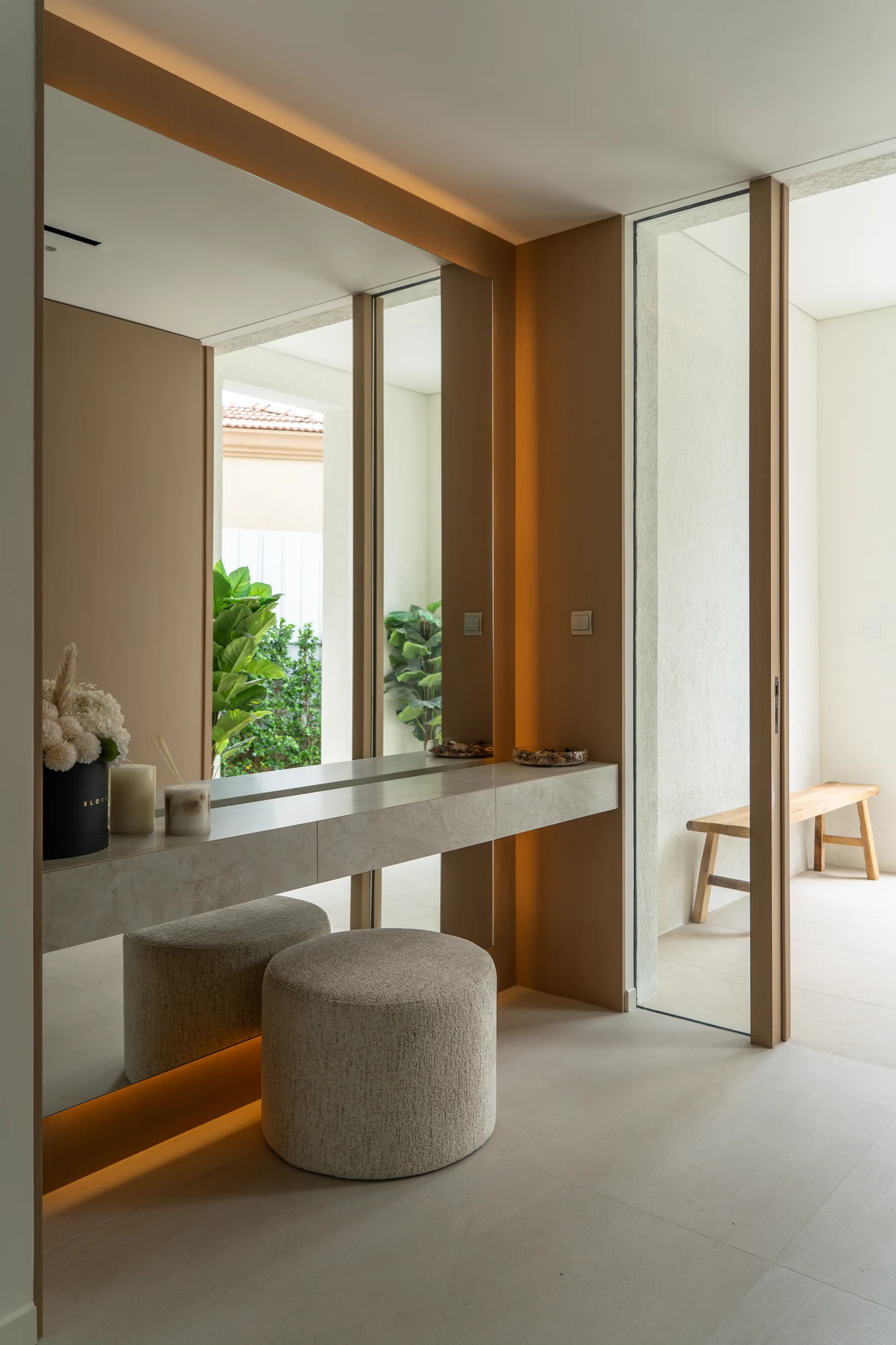 Floating corridor chest, grand mirror and warm lighting in a Jumeirah Islands villa