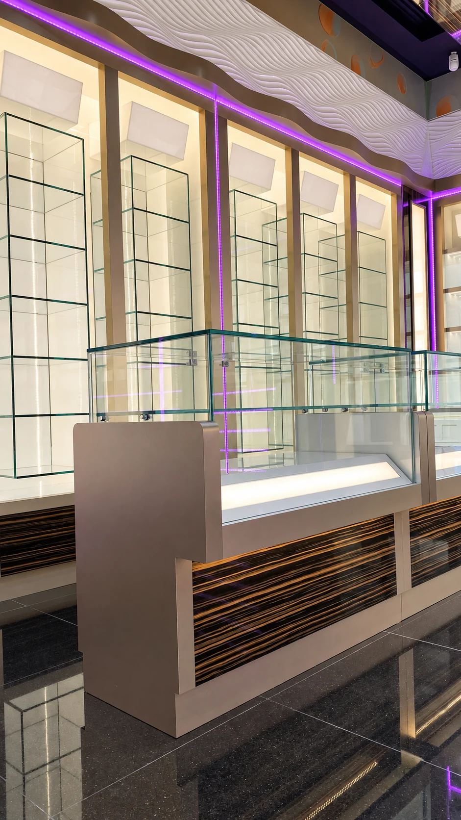 Glass display counter with striped timber veneer and illuminated wall shelving